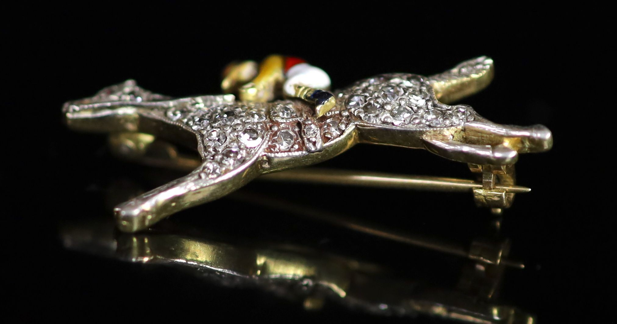 An early 20th century gold, diamond chip and enamel set 'horse and jockey' brooch